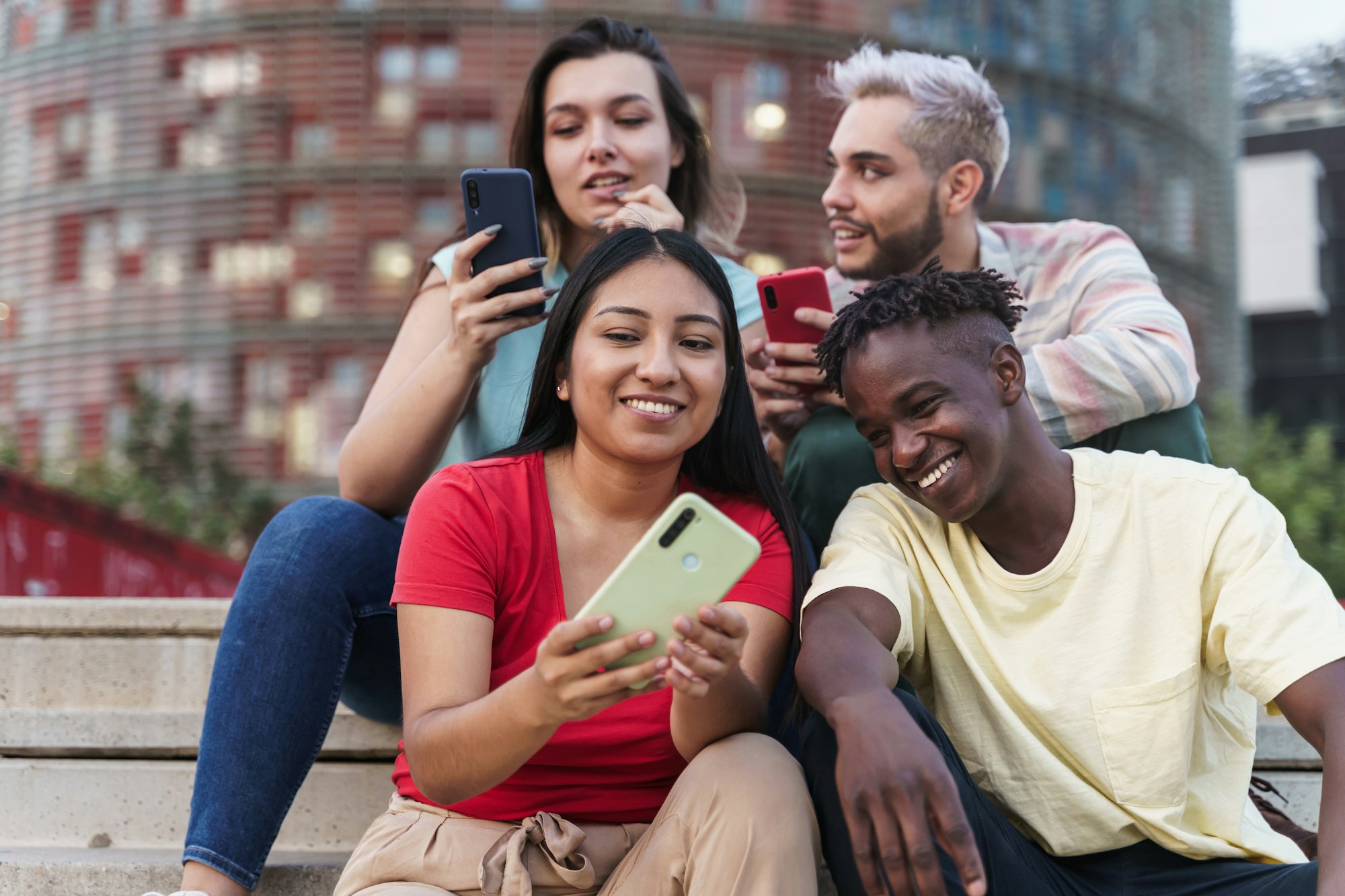 Latin and African American friends sharing social media content on smart phone